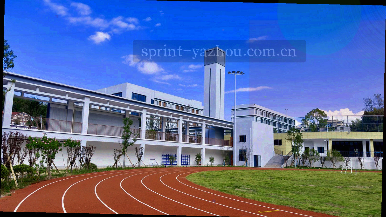 夜间体育场灯带沿弯道延伸的俯拍画面，灯光明亮、跑道线条清晰